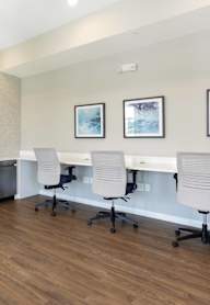 A room with a white counter and chairs.