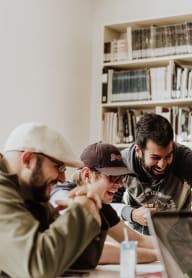 people in a library looking at a laptop