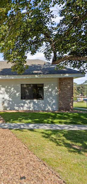 A house with a grey roof and a stone wall.