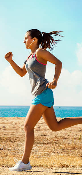 A woman is running on a beach.