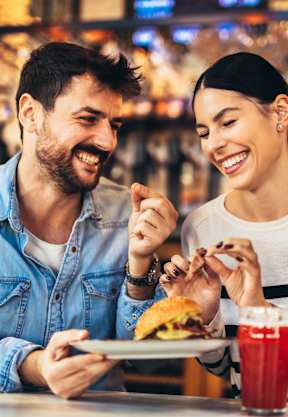A man and a woman are enjoying a meal together in a restaurant.