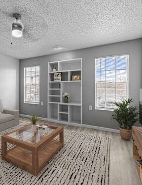 A living room with a grey couch, a wooden coffee table, and a painting on the wall.