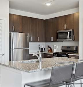 A kitchen with black cabinets and a checkered floor.