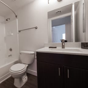 a bathroom with a toilet sink and tub and a mirror