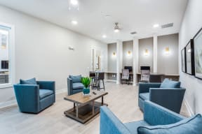 a living room with blue couches and chairs and a coffee table with a plant on it