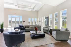 A spacious living room with grey and black furniture.