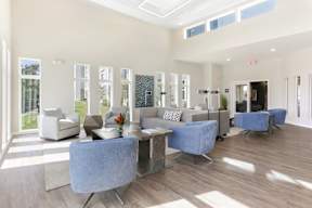 A spacious living room with a blue chair in the foreground.