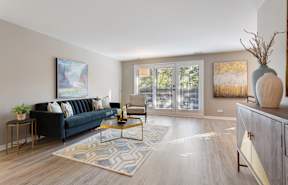 A modern apartment living room with clean lines and hardwood flooring.