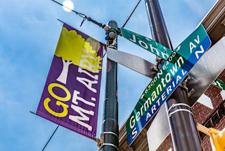 A street sign pole with a sign for Germantown and a banner that says Go Mt. Airy.