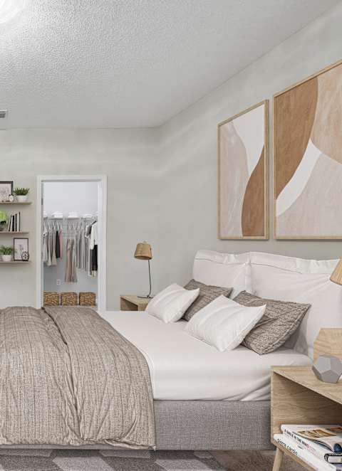 A bedroom with a bed, nightstand, and a dresser with a mirror.