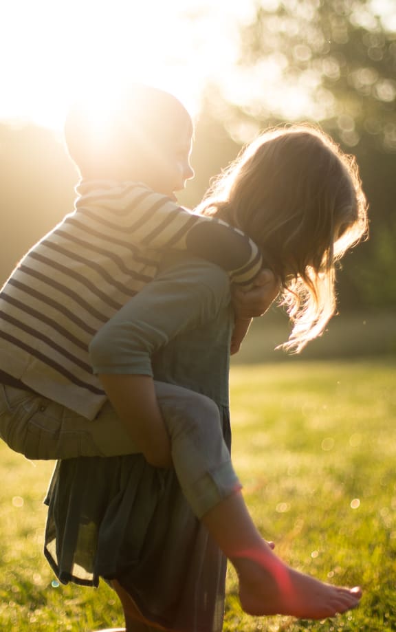 a boy and a girl hugging in the sun