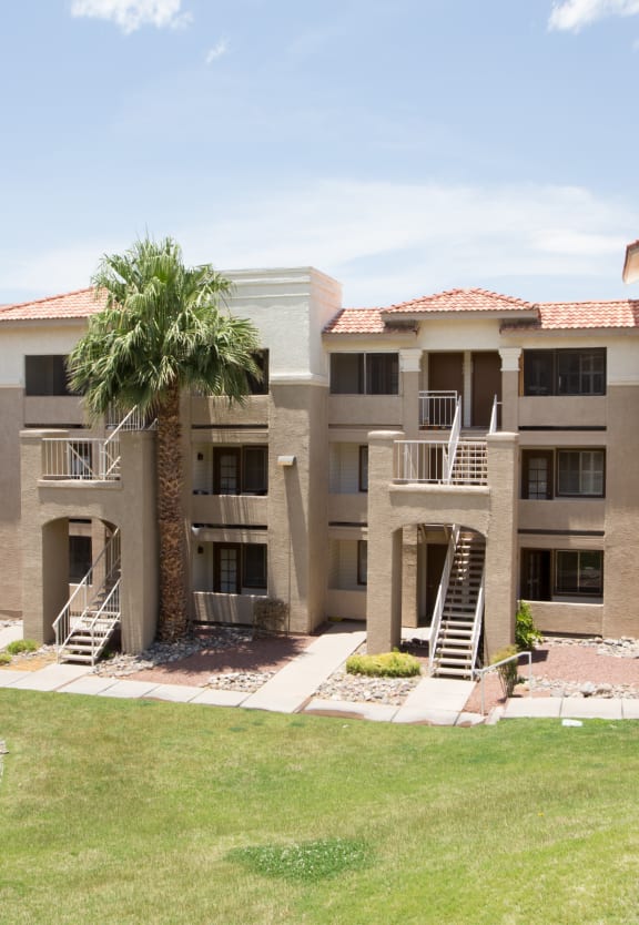 an exterior view of an apartment building with palm trees at Promontory, Tucson, 85704