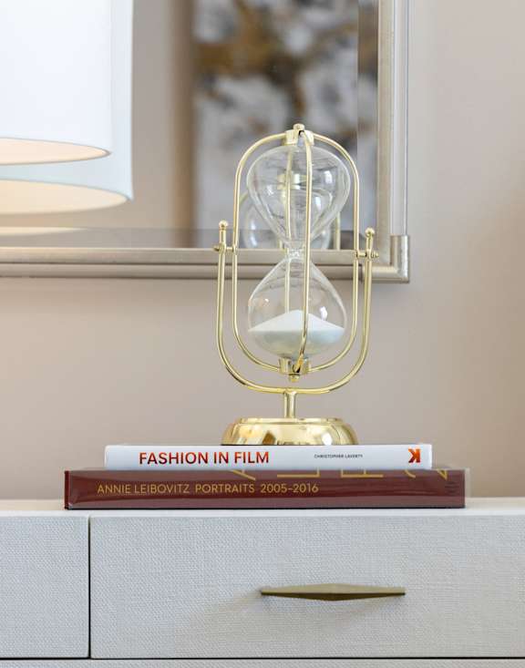 a nightstand with two books and a lamp on top of it