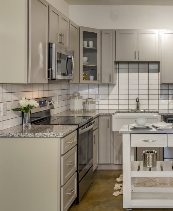 a large kitchen with stainless steel appliances and white counters