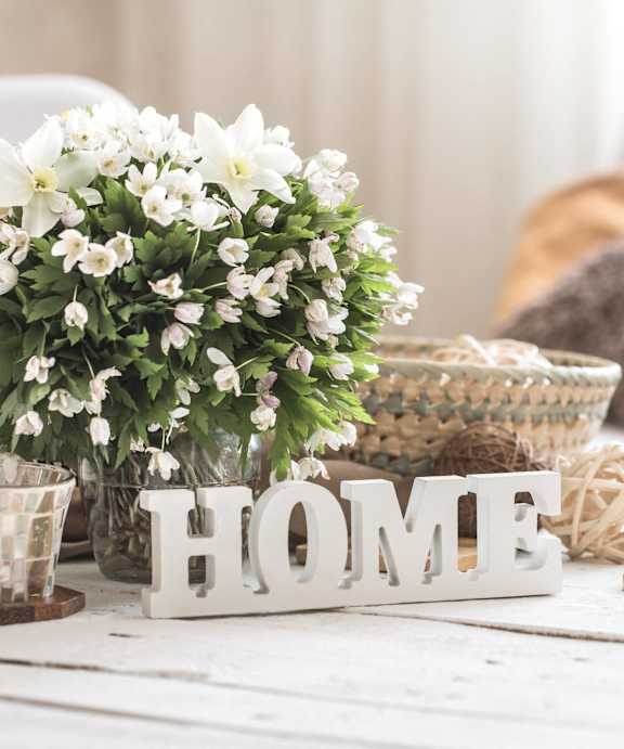 a table with a bunch of flowers and a home sign
