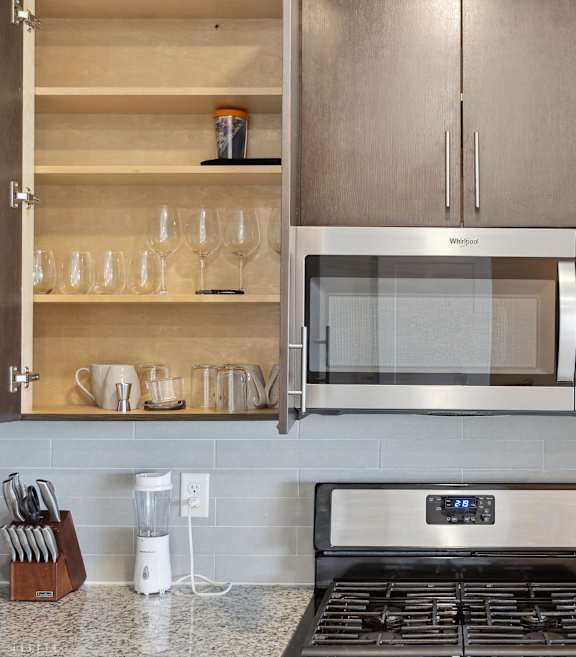 A kitchen with black cabinets and a checkered floor.