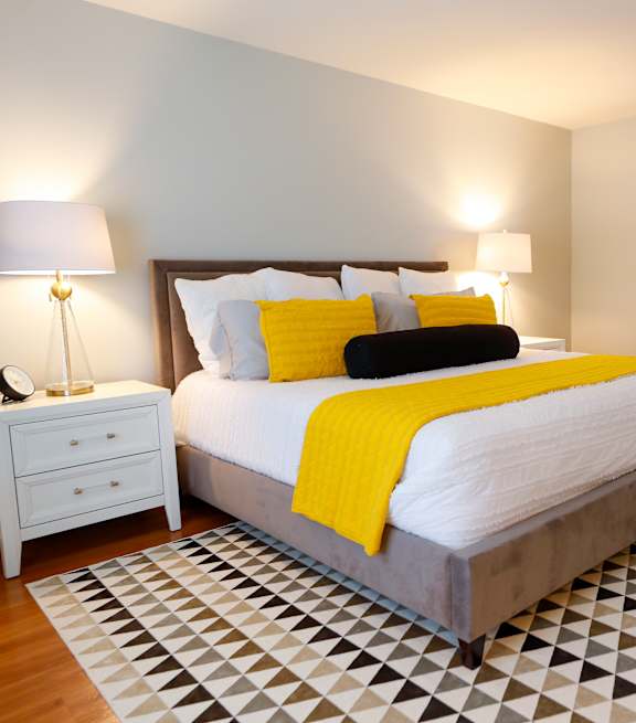 A bedroom with a large bed and a painting above it.