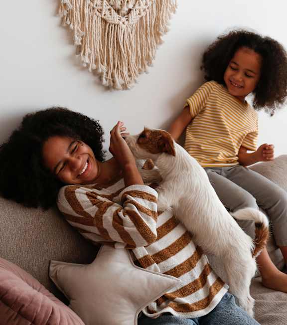 Two Girls Playing with a Dog on the couch at The Foundry Apartments, Bordon, GU35 9FE