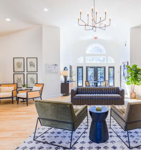 A living room with a large window, a sofa, a chair, and a table.