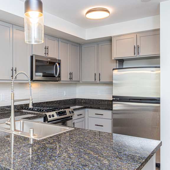 a kitchen with granite countertops and wooden cabinets at 128 on State, Kirkland, 98033