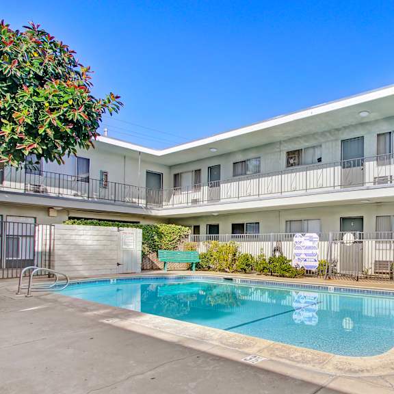 A pool in a courtyard surrounded by apartment buildings.