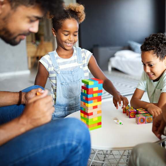 A group of people playing with colorful blocks together.