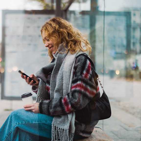 a woman sitting on a bench looking at her cell phone at Creekside Canopy, Charlotte, NC
