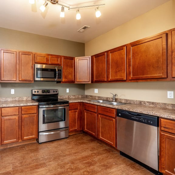 a kitchen with stainless steel appliances and wooden cabinets