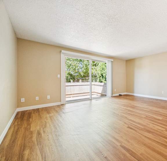 Empty room with wooden floors and white walls.
