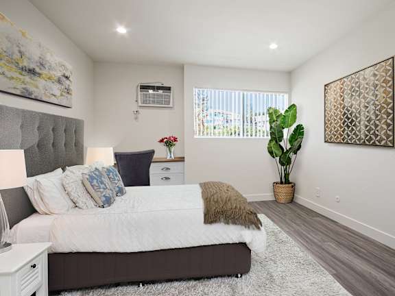 A bedroom with a large bed and a painting on the wall.