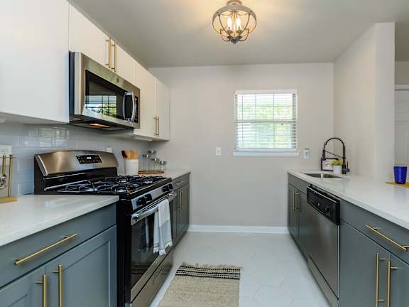 a kitchen with gray cabinets and white countertops