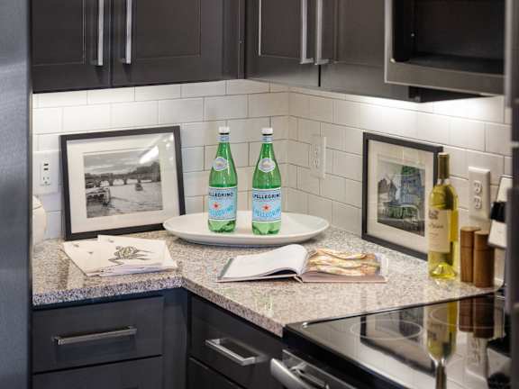 a kitchen with black cabinets and a counter with two bottles of water on it