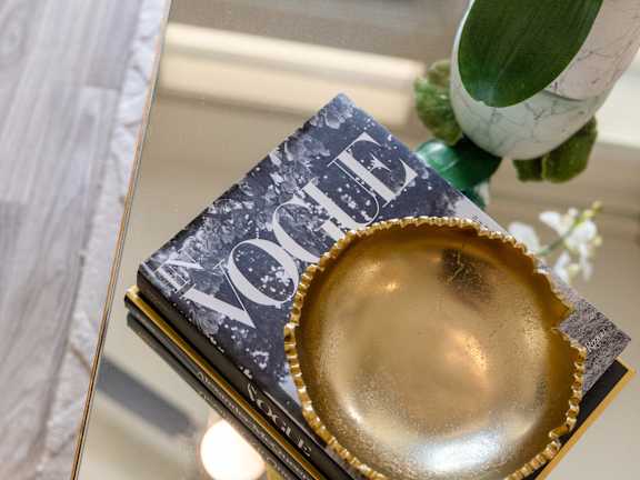a gold plate on top of a stack of books on a table