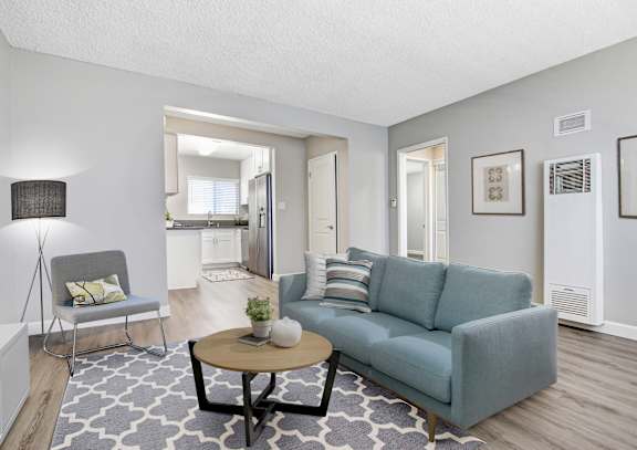 A living room with a grey couch, a white chair, and a coffee table.