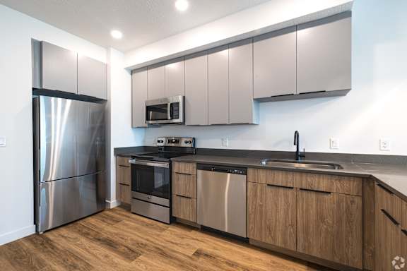 A modern kitchen with wooden cabinets and stainless steel appliances.