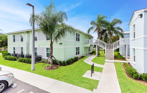 a building with a staircase and palm trees in front of it