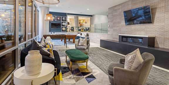 A modern living room with a fireplace and a flat screen TV mounted on the wall.
