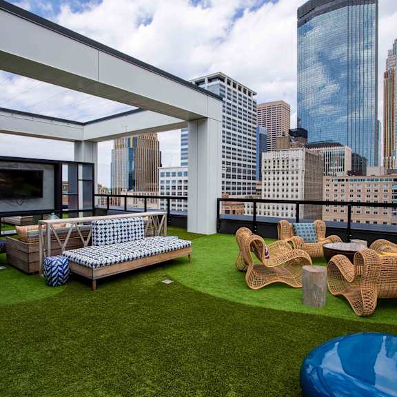 a roof top patio with furniture and a view of the city