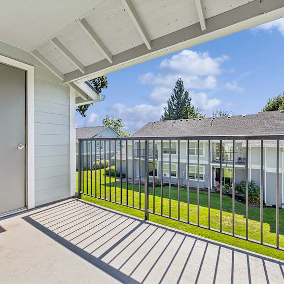 A patio with a metal railing and a sliding glass door.