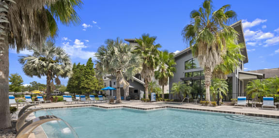 a large swimming pool with buildings in the background
