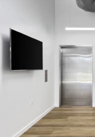 a hallway with two elevators and a flat screen tv on the wall at Jefferson Yards, Washington, 98402