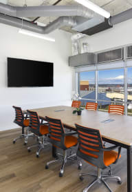 a conference room with a table and chairs and a flat screen tv on the wall at Jefferson Yards, Washington