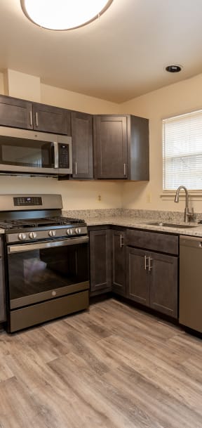 a kitchen with dark wood cabinets and stainless steel appliances at Carlson Woods Townhomes, Baltimore, MD, 21244