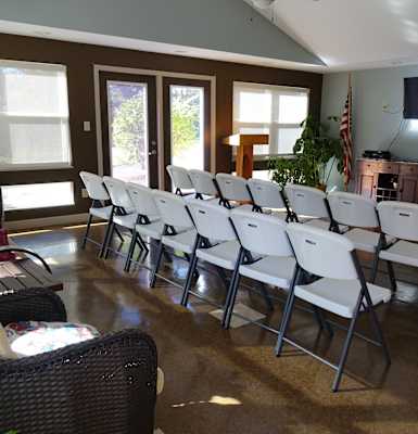 a room filled with white chairs and a flat screen tv