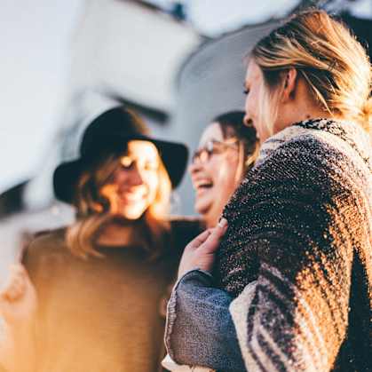 a group of women standing next to each other and laughing