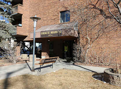 Grace Manor building with a bench in front.