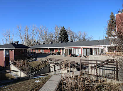 A building with a red roof and a black fence.