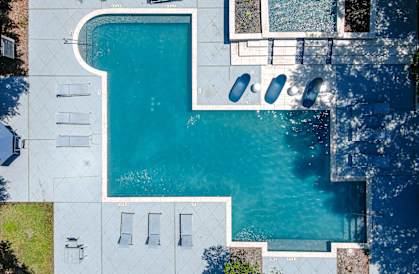 A swimming pool with a white fence and a white bench. at The Quarry Alamo Heights Apartments, San Antonio, Texas