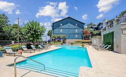 A blue building with a pool in front of it.