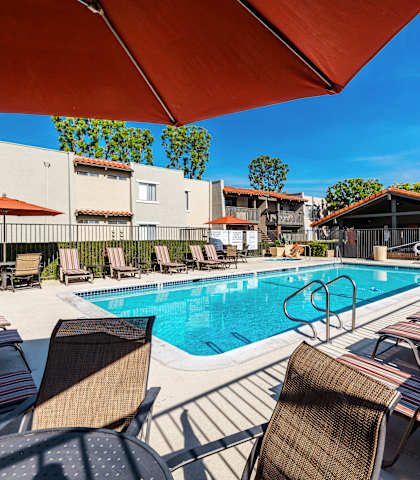 our apartments have a large pool and lounge chairs at CASA GRANDE APARTMENT HOMES, Cypress, CA